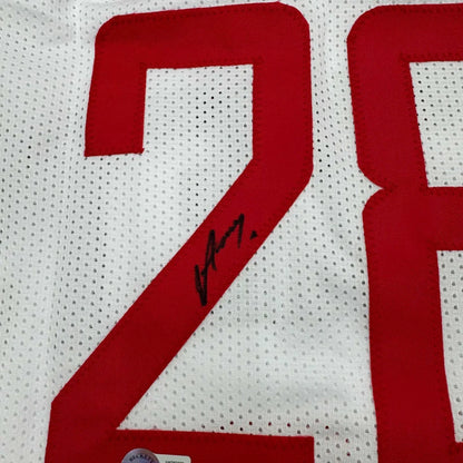 White sports jersey with red numbers and a black autograph, perfect for framing