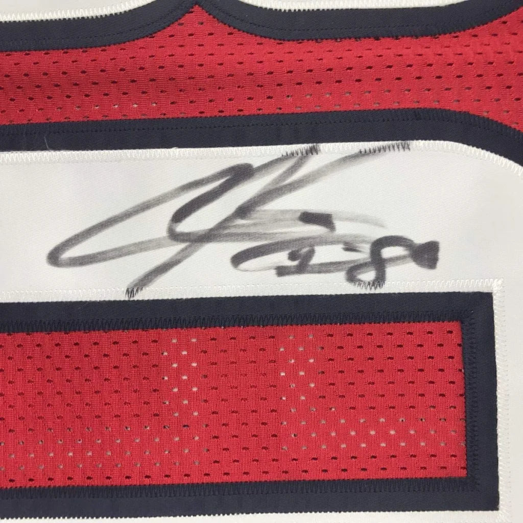Red and white Houston Texans jersey signed with black marker, perfect for fans