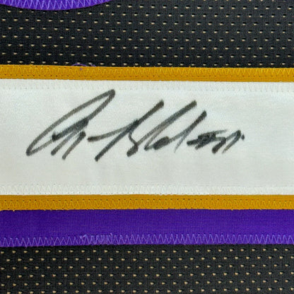 Black ink signature on white label with gold and purple trim on black mesh in framed autographed anquan boldin jersey