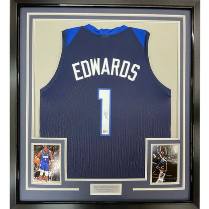 Back of a navy blue and royal blue basketball jersey with edwards name and number 1 signed by anthony edwards framed