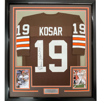 Framed autographed cleveland browns football jersey in brown with white and orange stripes signed by bernie kosar showing back side
