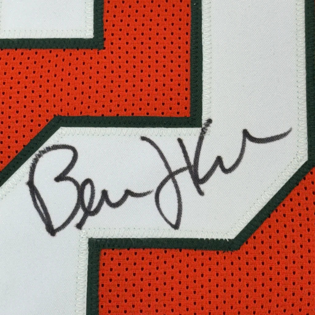 Black ink signature on a white patch of an orange and green mesh framed bernie kosar college football jersey