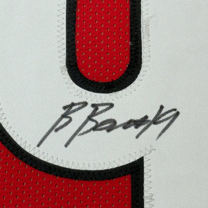Framed autographed red and black mesh college football jersey with white stitched border and number 0 by brock bowers