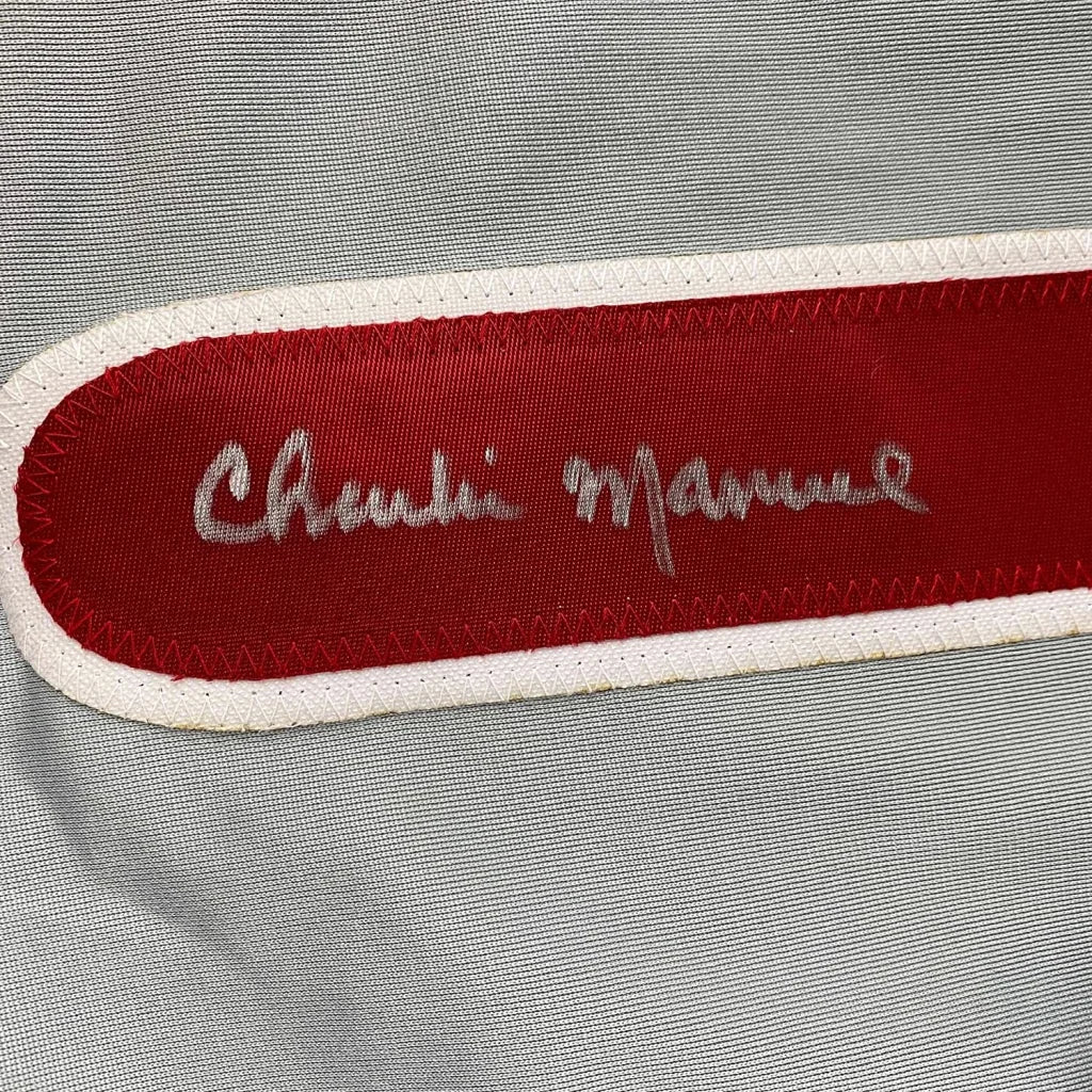 Red Chanel label with silver embroidered script on framed signed Charlie Manuel Phillies jersey