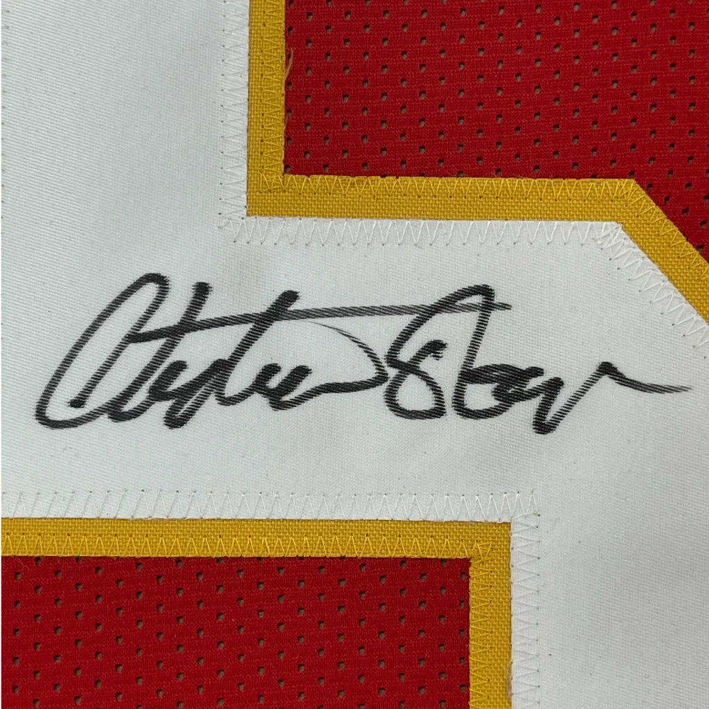 Black ink Clyde Lee signature on white patch in framed autographed Christian Okoye Kansas City Chiefs jersey with JSA COA