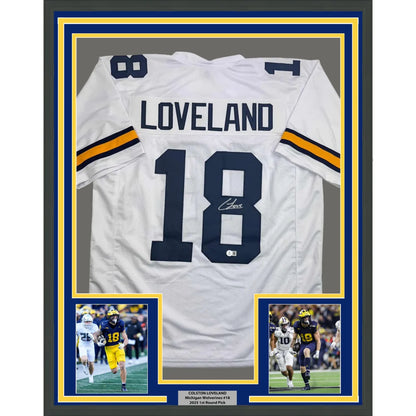 Back side of framed autographed white Michigan Wolverines football jersey with navy and gold accents featuring Loveland 18