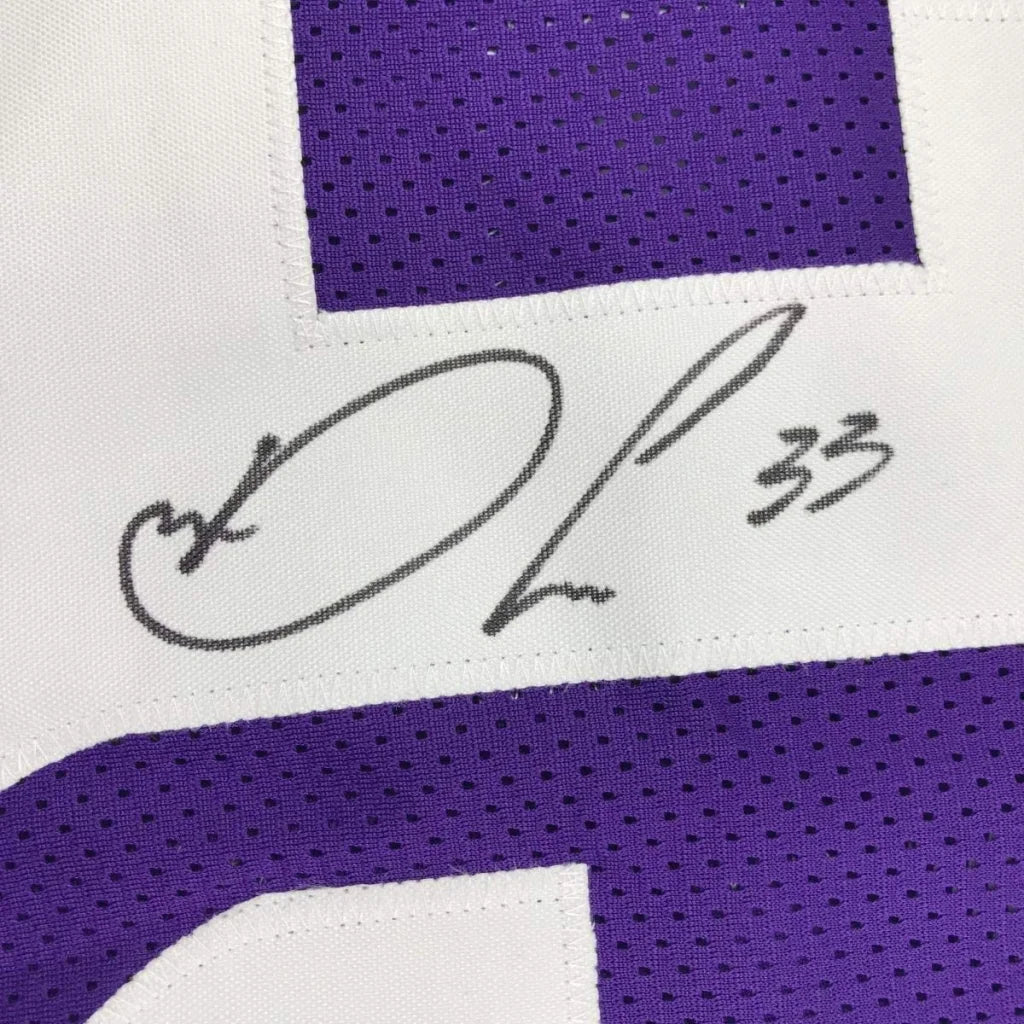 Framed autographed white and purple dalvin cook football jersey with signature and number 33 for display