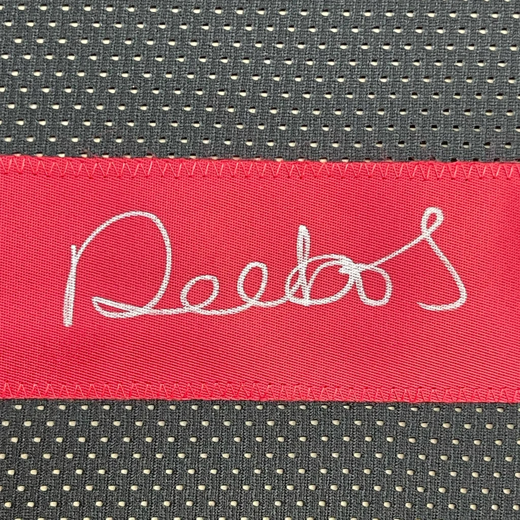 Red fabric label with white cursive text on dark gray mesh fabric of Deebo Samuel jersey