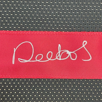 Red fabric label with white cursive text on dark gray mesh fabric of Deebo Samuel jersey