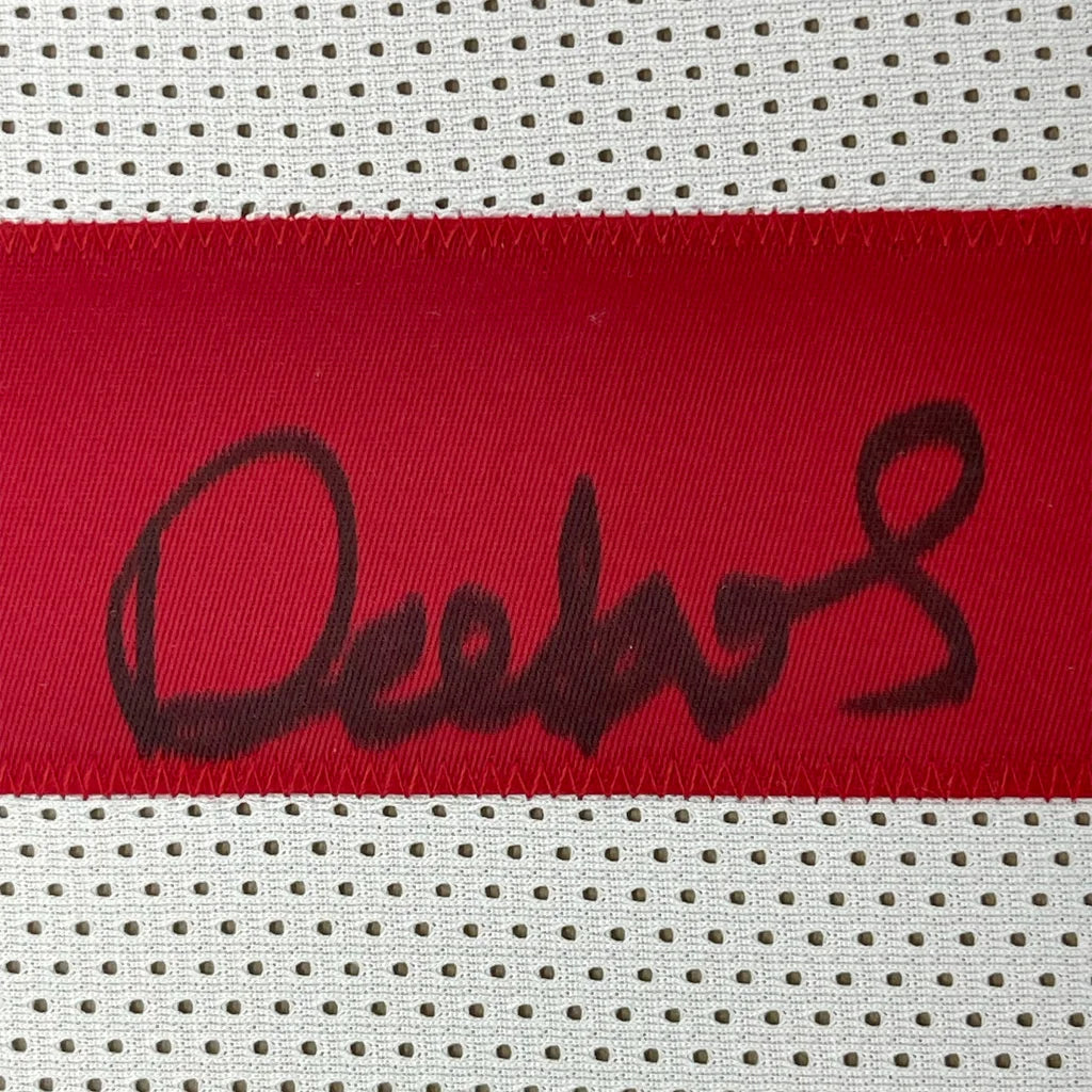 Red fabric strip with black autograph on white mesh background from Deebo Samuel 49ers jersey