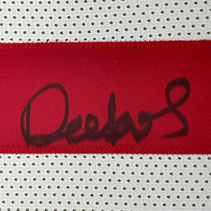 Red fabric strip with black autograph on white mesh background from Deebo Samuel 49ers jersey