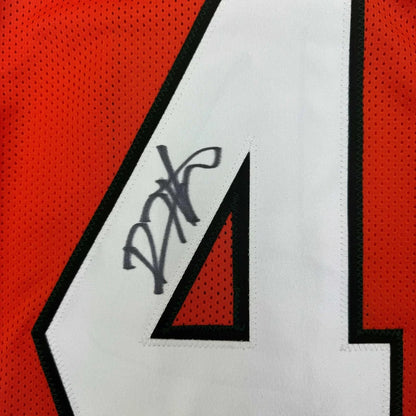 Autographed orange Miami Hurricanes jersey with number 4 in a framed display