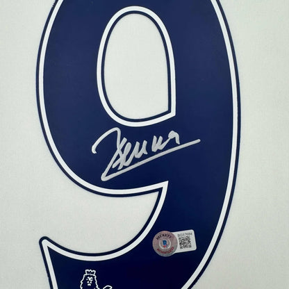 A navy blue number nine patch with white outline featuring an autograph and beckett authentication on a framed dimitar berbatov tottenham jersey