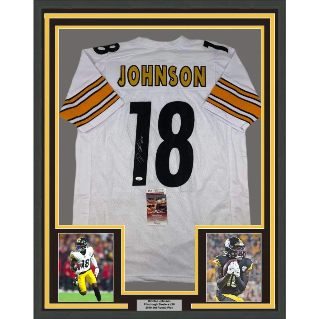 Front view of a framed autographed Diontae Johnson white Pittsburgh Steelers football jersey with black number 18 and striped sleeves