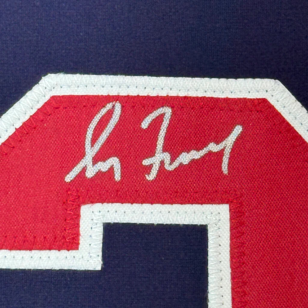 Framed autographed Greg Maddux Atlanta Braves jersey with red and white embroidered C on navy fabric