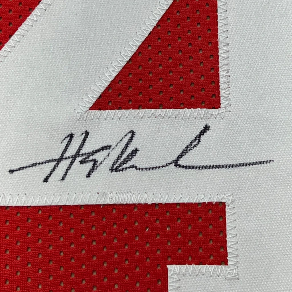 Red and white sports jersey with black marker autograph, professionally framed for display