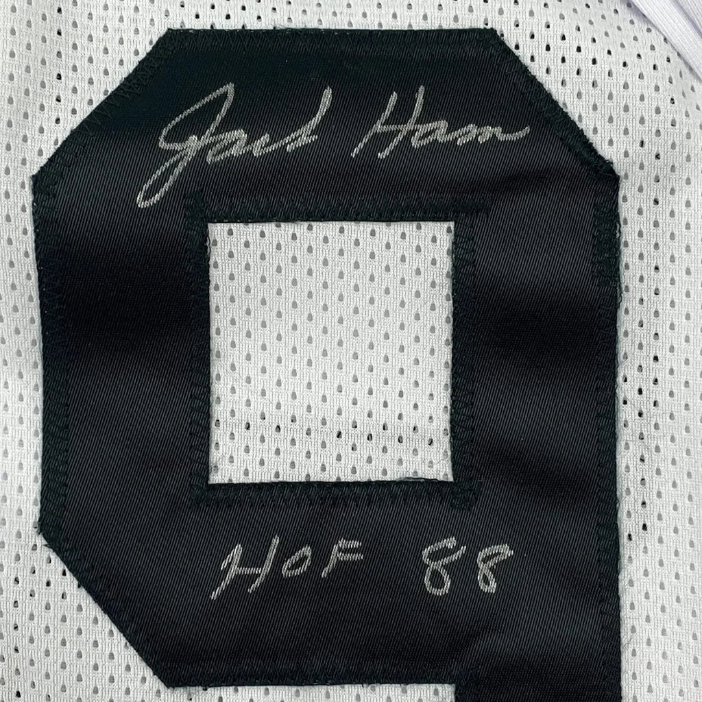 Autographed black and white Jack Ham sports jersey with action photos frame