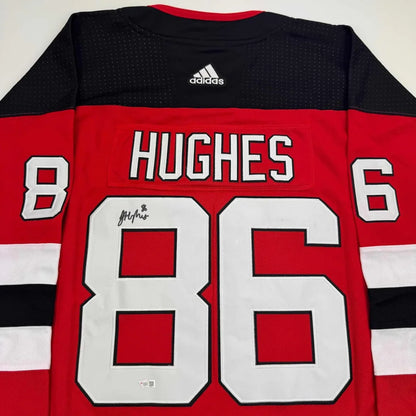 Red and black Jack Hughes New Jersey Devils jersey with white numbers, autographed and framed