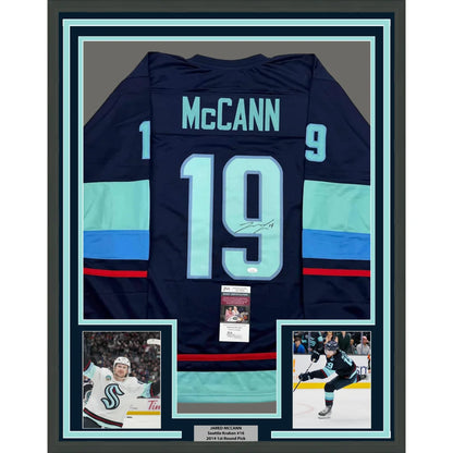 Framed autographed navy blue seattle kraken hockey jersey with teal stripes featuring mccann 19 on the back