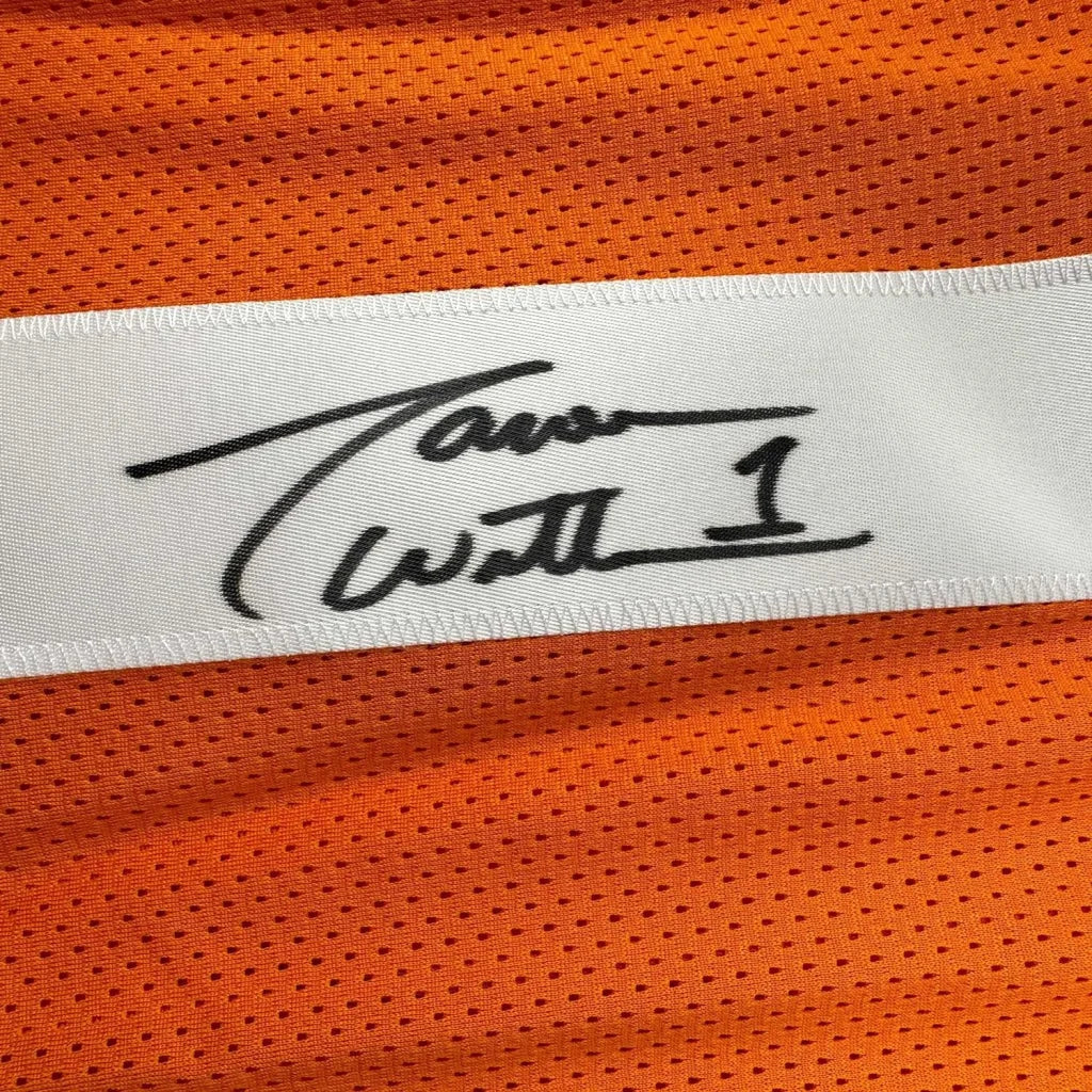 A white label with a black tavon wilson signature stitched on bright orange mesh in a framed signed jason witten jersey