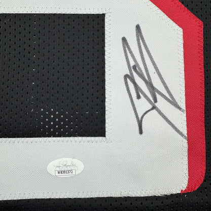 Black Jesse Bates III signed sports jersey with white numbers, autograph, and authentication sticker