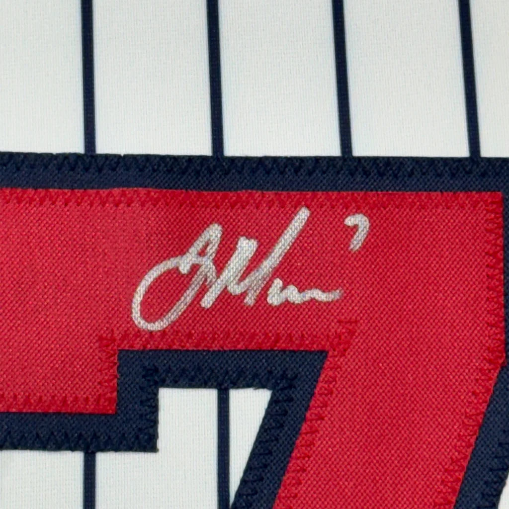 Autographed Joe Mauer jersey with number 7 displayed with photos and plaque