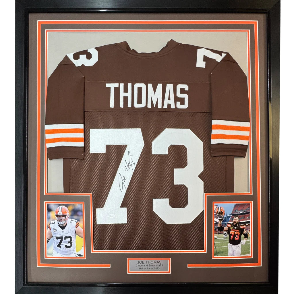 Framed autographed brown cleveland browns football jersey with white number 73 and name thomas displayed from back side