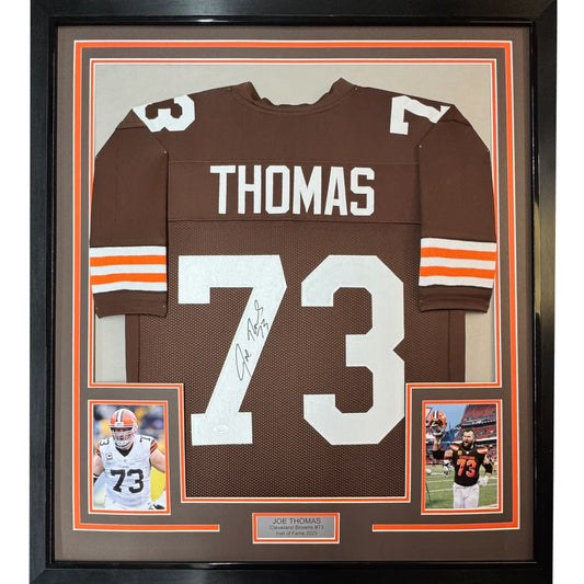 Framed autographed brown cleveland browns football jersey with white number 73 and name thomas displayed from back side