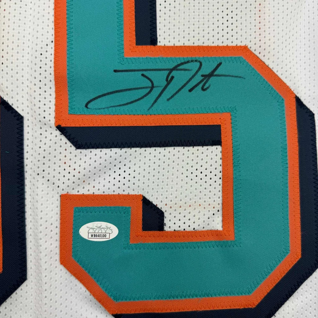 Autographed Miami Dolphins white jersey with teal and orange numbers in framed display