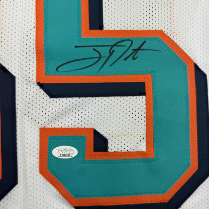 Autographed Miami Dolphins white jersey with teal and orange numbers in framed display