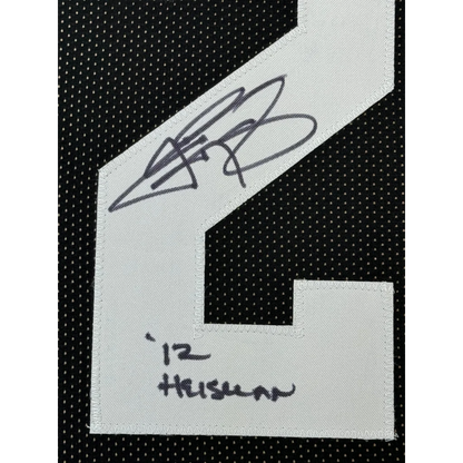 White embroidered patch with black signature and number 12 on black mesh fabric of framed autographed Johnny Manziel jersey