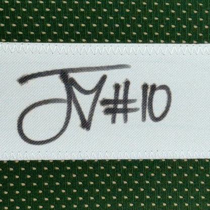 Green fabric with white polka dots and sewn white label on Autographed Jordan Love Jersey