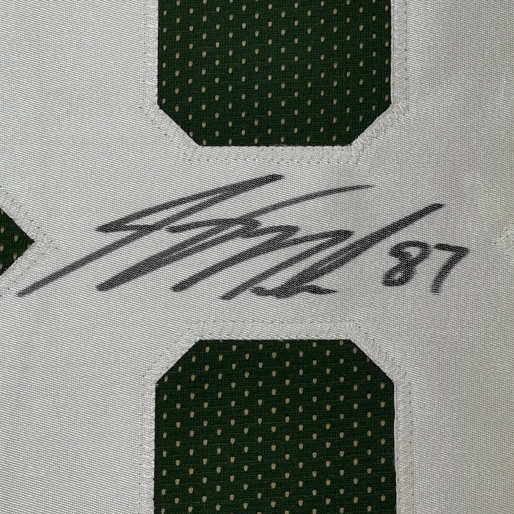 Close-up of signed Bobby Moore 87 green white soccer jersey on framed Jordy Nelson JSA COA display
