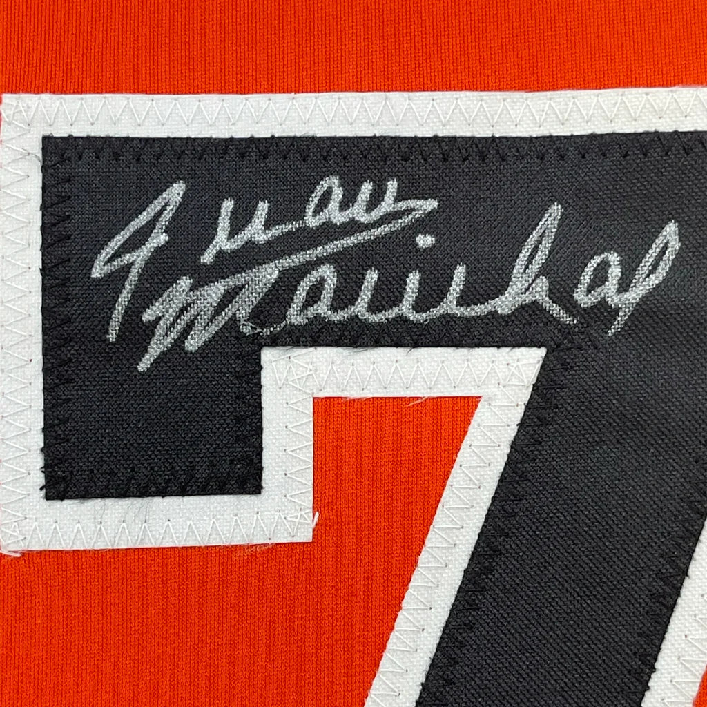 Black and red sports jersey patch with white stitched border and silver embroidered signature above number 7