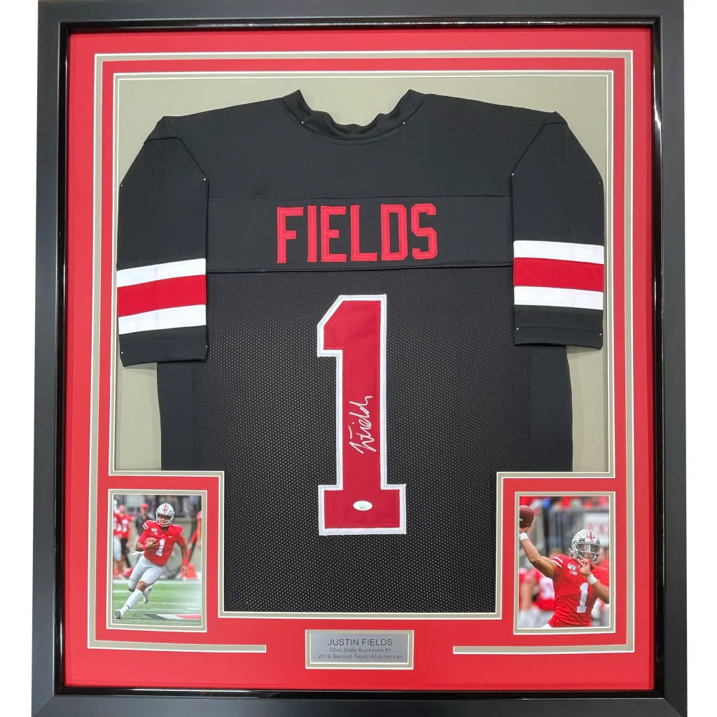 Back of a framed autographed ohio state black college football jersey with red and white lettering fields number 1 signed by justin fields