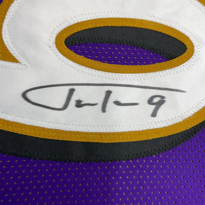 Purple and gold Justin Tucker Ravens signed jersey with photos in a framed display