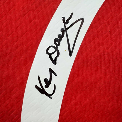 Framed autographed Kenny Dalglish Liverpool red Carlsberg jersey with black ink signature, Beckett BAS COA