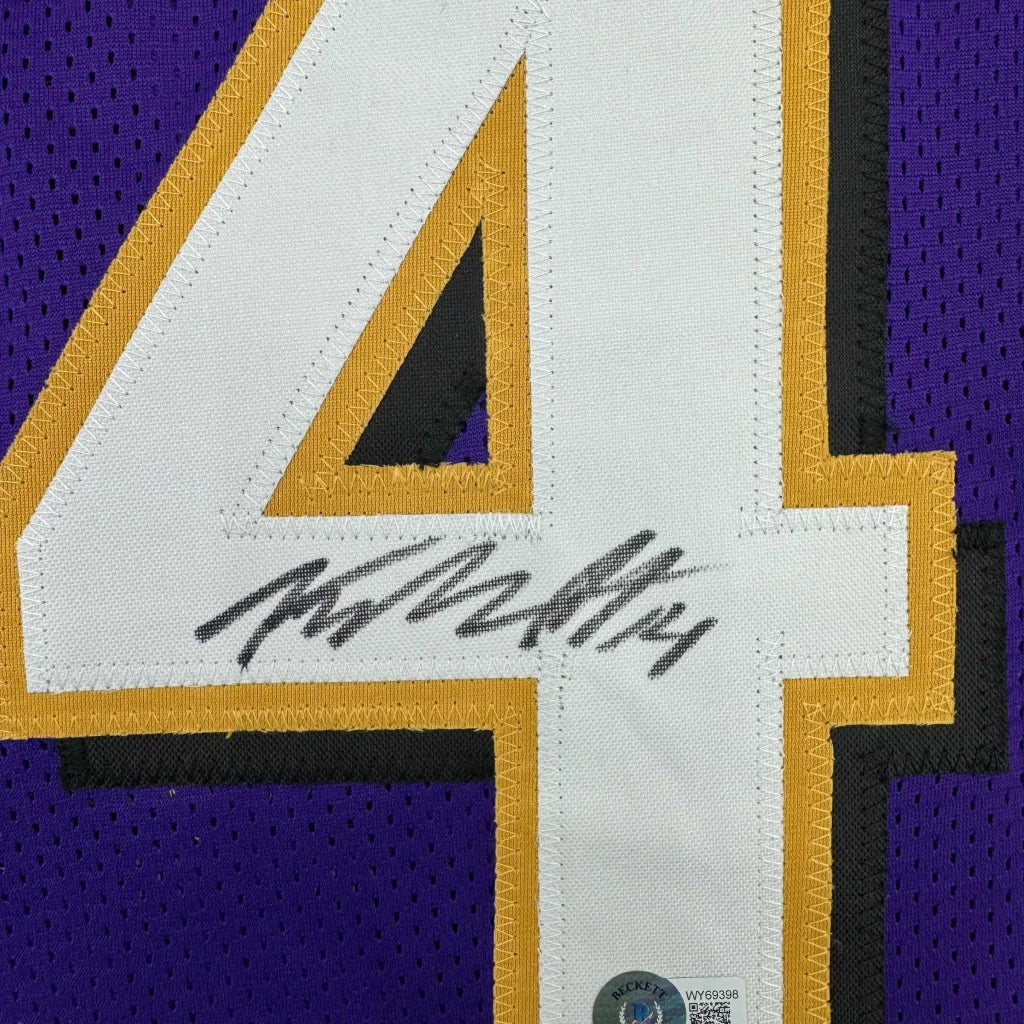 Framed autographed Baltimore purple and gold mesh football jersey with white number four and yellow outline by Kyle Hamilton