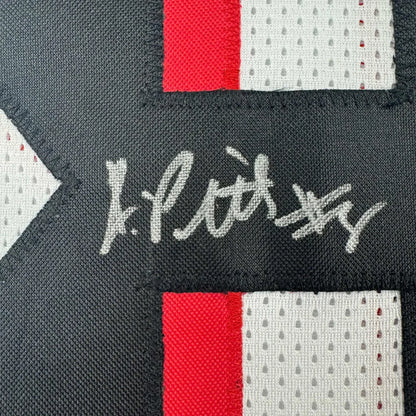 Black and red mesh fabric patch with white embroidered signature on framed autographed kyle pitts jersey