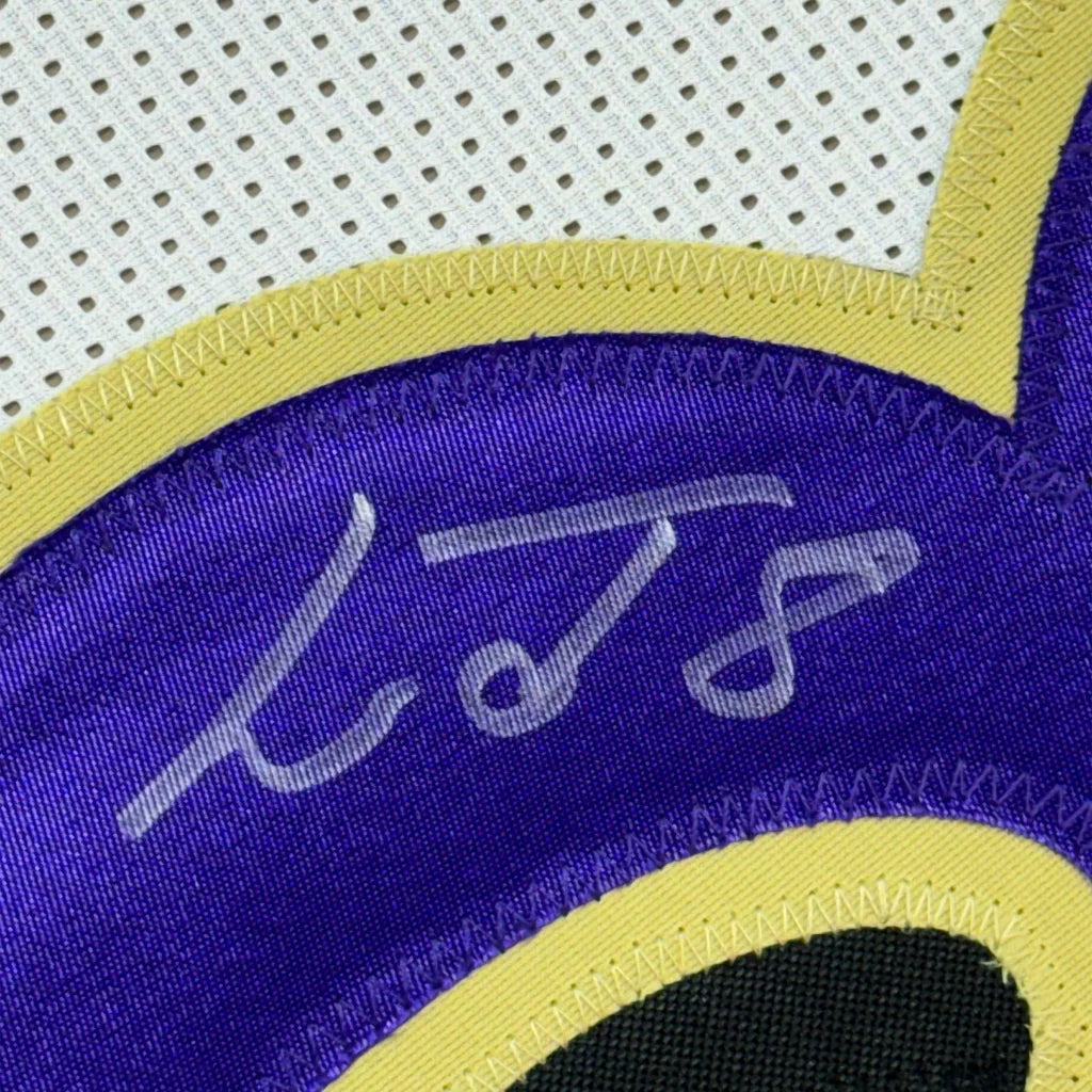 Framed autographed Lamar Jackson Baltimore Ravens white jersey with purple and yellow accents
