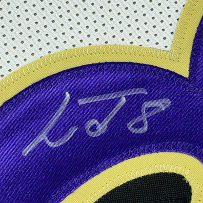Framed autographed Lamar Jackson Baltimore Ravens white jersey with purple and yellow accents