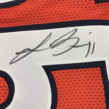 Autographed orange and white Bears jersey with player photos on display in frame