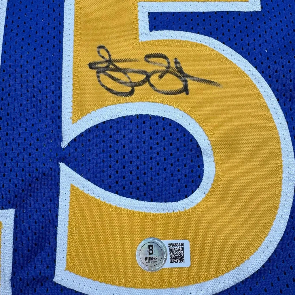 Autographed blue and yellow Warriors jersey with authentication stickers ready to hang
