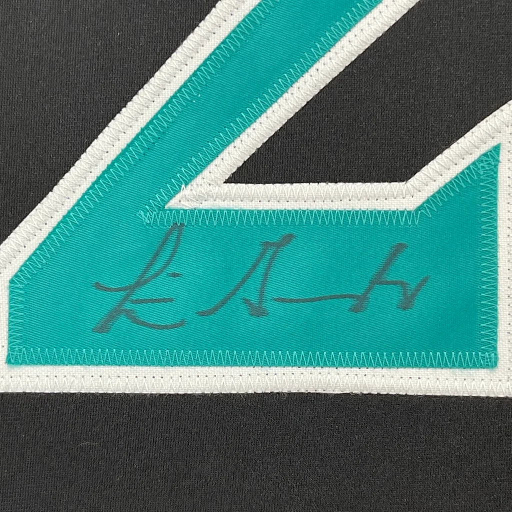 Black fabric with teal and white number 4 appliqué and gray autograph on jersey