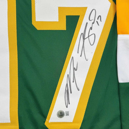 Framed autographed green and yellow minnesota hockey jersey with number 7 and white signature strip along the side