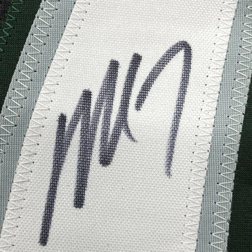 Framed autographed Michael Vick Philadelphia Eagles jersey with black signature on white strap