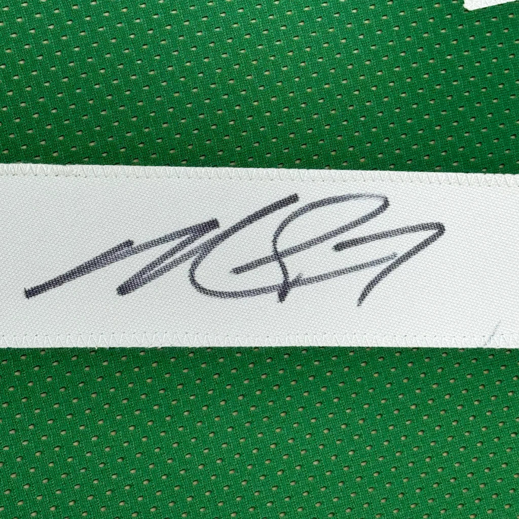 Green perforated fabric with white strip and signature on professionally framed Michael Vick Eagles Jersey