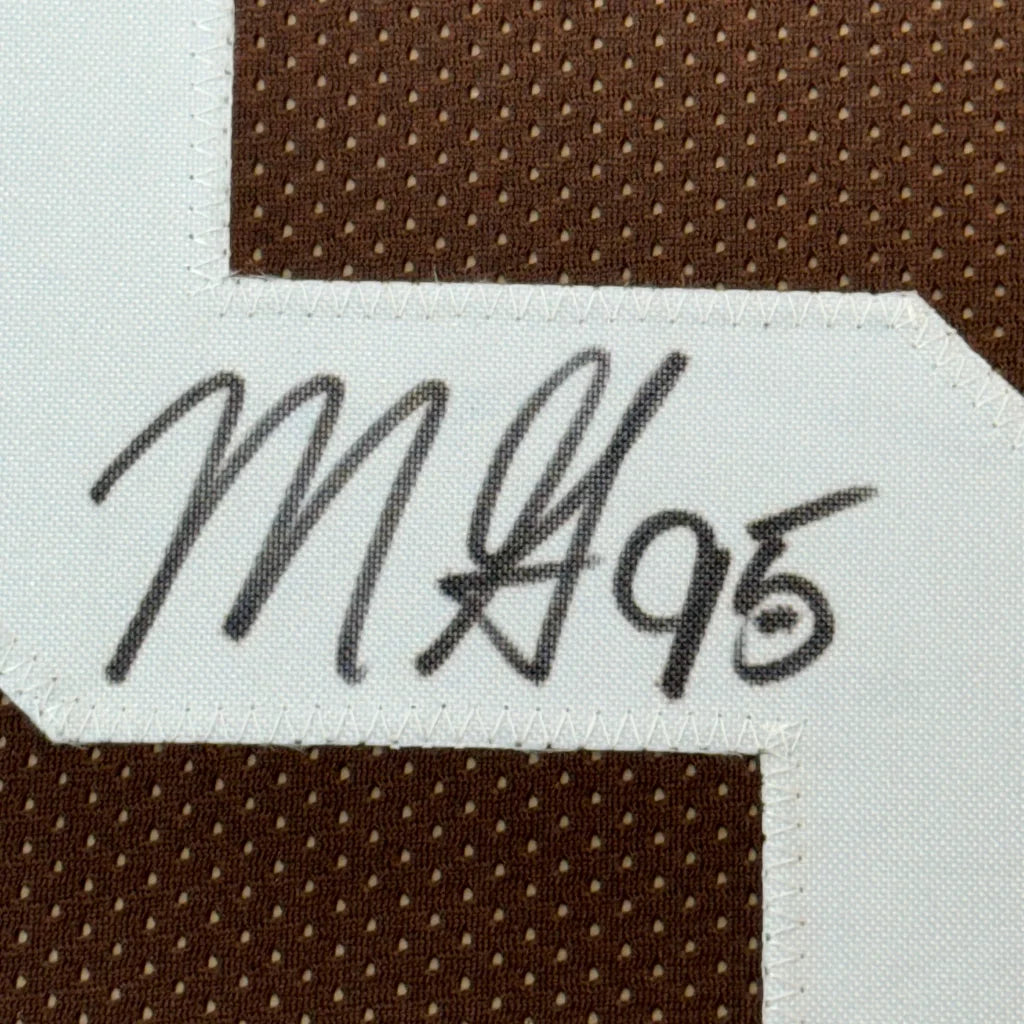 Brown Browns jersey with white number and black autograph, framed in a photos museum style