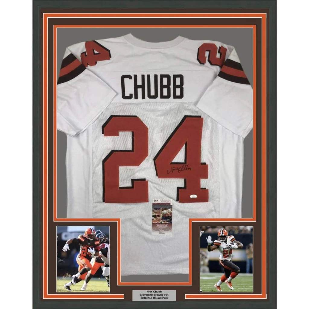 Back side of a framed autographed white cleveland browns football jersey with red number 24 and black lettering signed