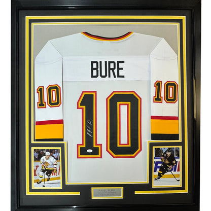 Autographed Vancouver white hockey jersey with Bure 10, player photos, and plaque for man cave